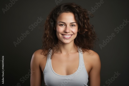 studio beauty portrait of a smiling confident woman in tank top with down syndrome on gray background