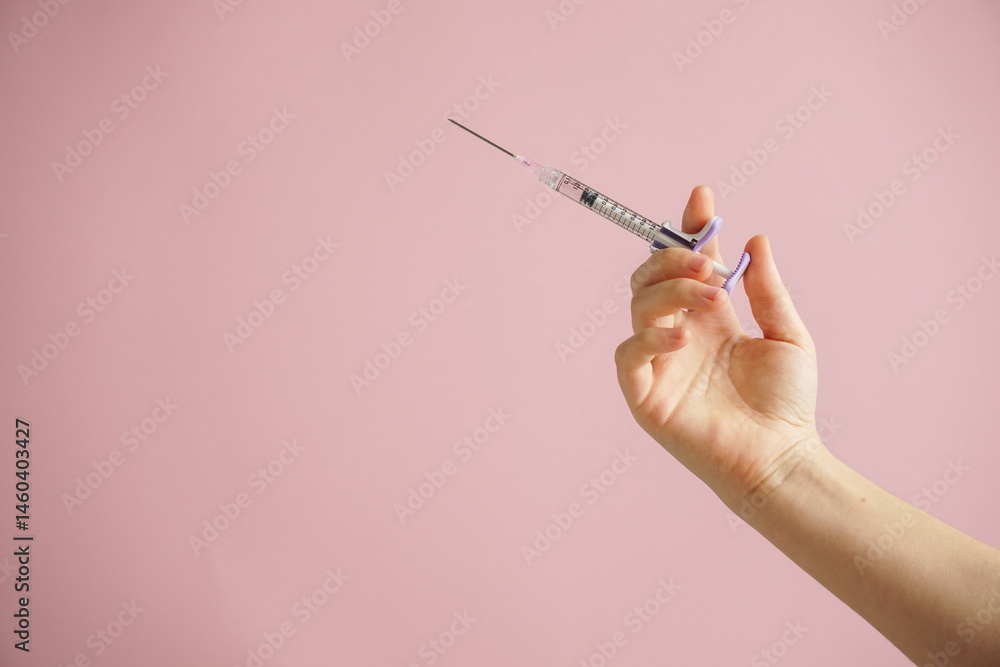 gloved hand holding multiple colorful syringes, against a soft background. Conceptual image related to medicine, beauty injections, or cosmetic procedures gloved hand holding multiple colorful syringes, against a soft background. Conceptual image related to medicine, beauty injections, or cosmetic procedures