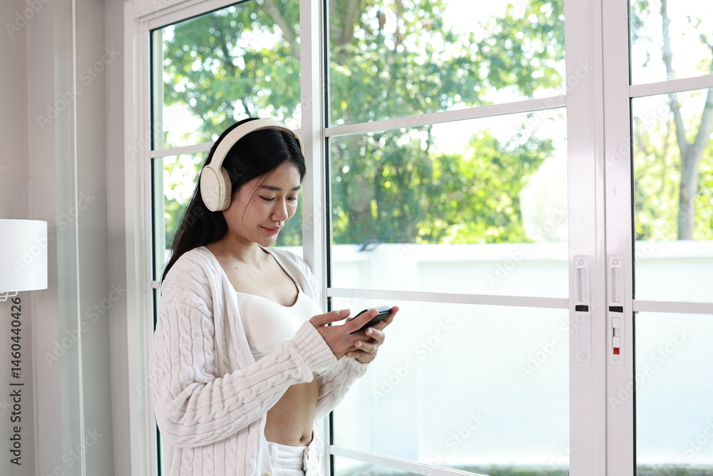 A cheerful woman relaxes on a cosy sofa in her modern apartment, enjoying her weekend with a smile and mobile phone in hand. A cheerful woman relaxes on a cosy sofa in her modern apartment, enjoying her weekend with a smile and mobile phone in hand.