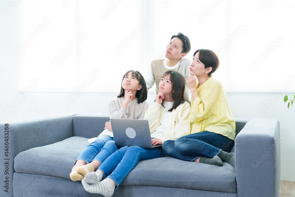 Obraz premium 困った表情でパソコンを使う家族