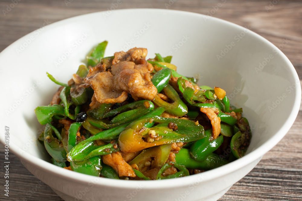 A closeup view of a bowl of sauteed pork. A closeup view of a bowl of sauteed pork.