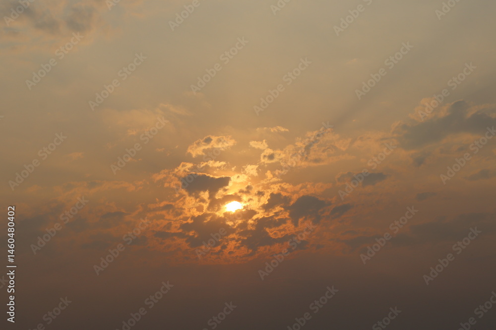 Sunlight Breaking Through Dense Clouds During Sunset with Golden Rays