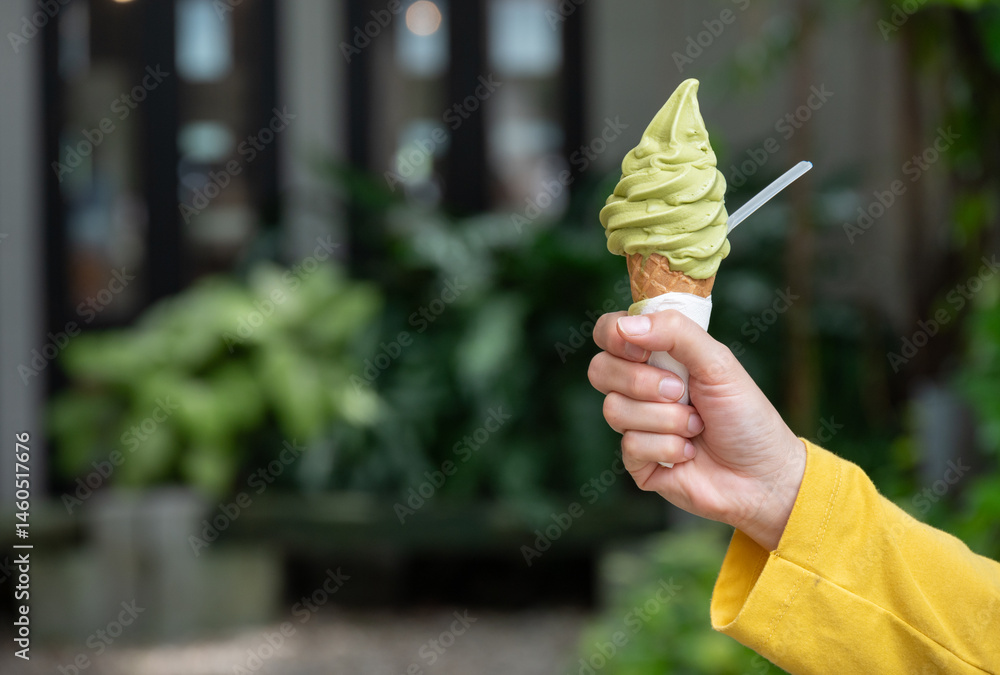 Cropped shot view of someone holding a green tea ice cream. Ice creams are dairy-based frozen foods usually consumed as snacks or desserts.