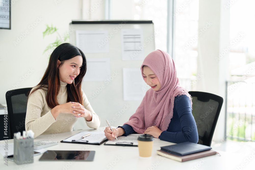 Young Asian Muslim Businesswoman in Hijab Meeting with Partner Asian woman Discussing Project Documents at Office Workspace and Planning Collaboration Young Asian Muslim Businesswoman in Hijab Meeting with Partner Asian woman Discussing Project Documents at Office Workspace and Planning Collaboration
