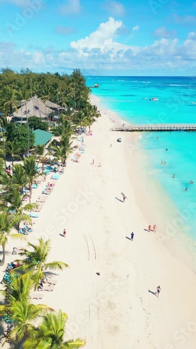 Vacationers sunbathing and swimming on the white tropical beach of Punta Cana