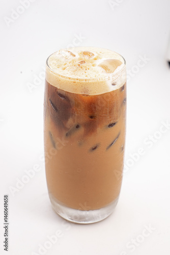 iced coffee with cream and ice cubes served in tall clear glass with foamy top photographed on white background. High quality photo