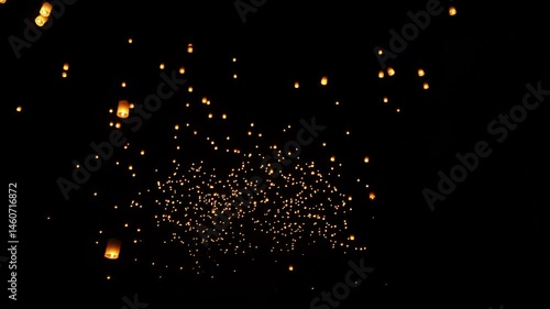 Hundreds of lanterns illuminate the night sky during Yi Peng celebration in Chiang Mai, creating a magical, glowing scene.