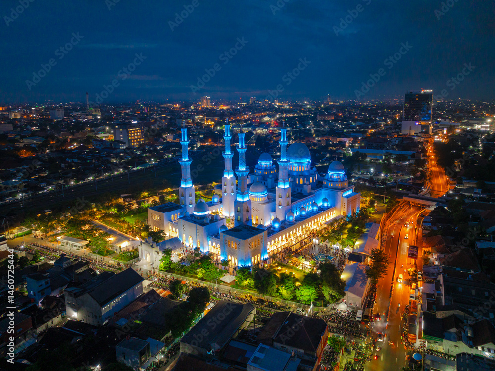 Obraz premium Aerial Night View of Sheikh Zayed Grand Mosque in Solo, Central Java, Indonesia Illuminated with Blue Lights Surrounded by Cityscape