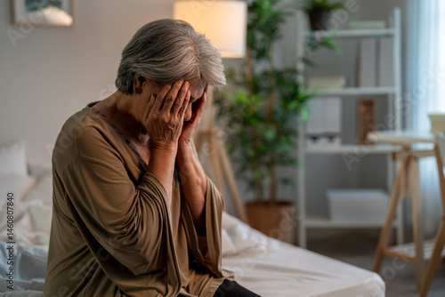 Asian senior elderly depressed woman sitting alone in bedroom at home. 