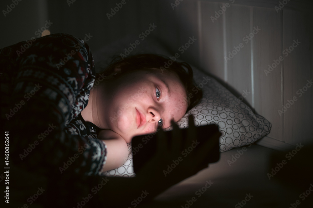 Girl using smart phone while lying on bed in bedroom Girl using smart phone while lying on bed in bedroom