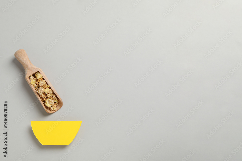 Muesli in a wooden scoop on a gray background