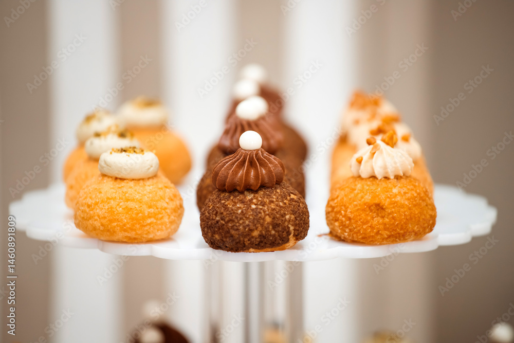 Different kinds of beautiful pastry, small colorful sweet cakes, macaron, and other dessert in the sweet buffet
