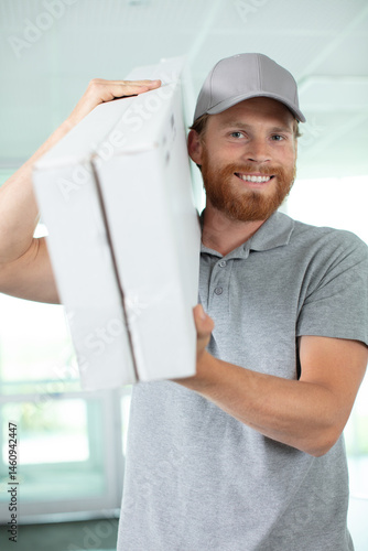 Obraz na płótnie man worker is carrying a box w salonie
