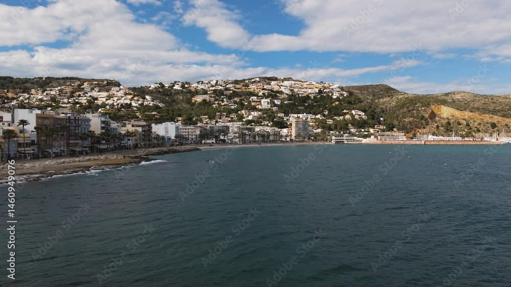 Turquoise ocean surrounds rugged coastline on a clear sunny day in Xabia, Spain Turquoise ocean surrounds rugged coastline on a clear sunny day in Xabia, Spain