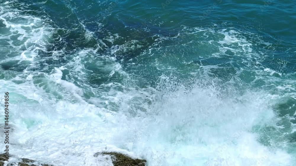 A dramatic close-up shot of ocean waves crashing against rocky shorelines, creating a powerful display of nature’s force with frothy white surf and clear blue water. Phuket, Thailand.
A dramatic close-up shot of ocean waves crashing against rocky shorelines, creating a powerful display of nature’s force with frothy white surf and clear blue water. Phuket, Thailand.