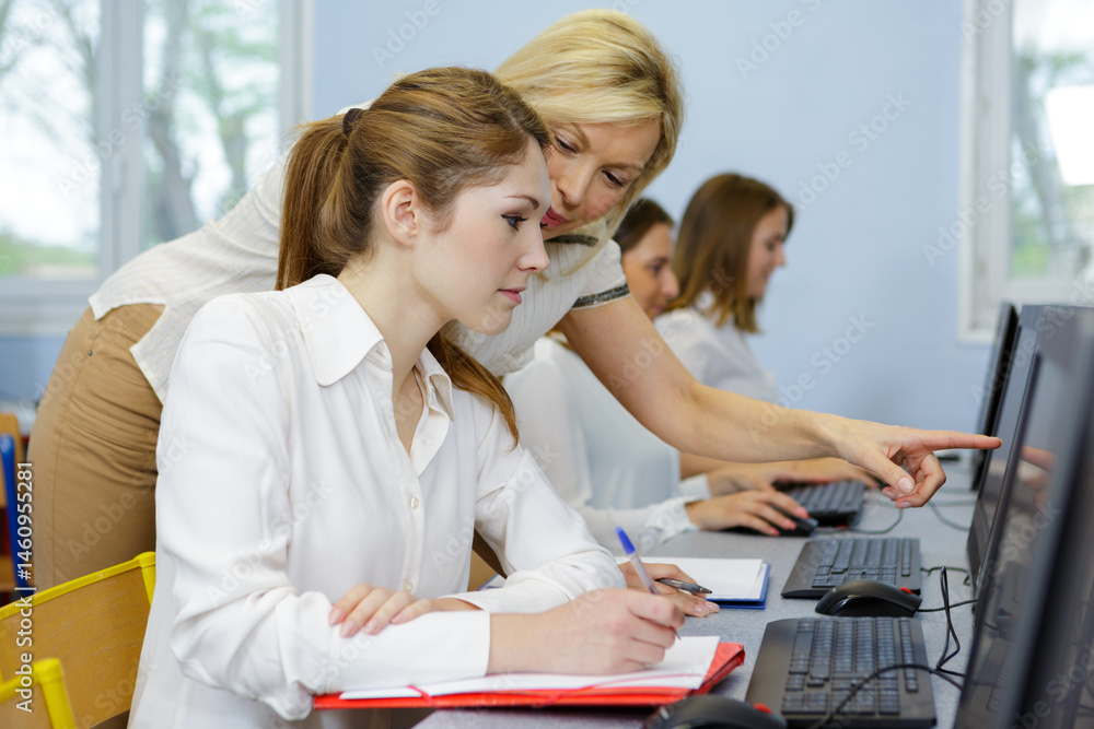 Fototapeta premium teacher helping her student in computer class