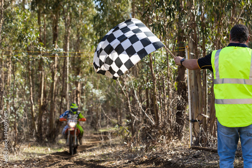 Race official waving chequered flag at finish of motorcycle race
