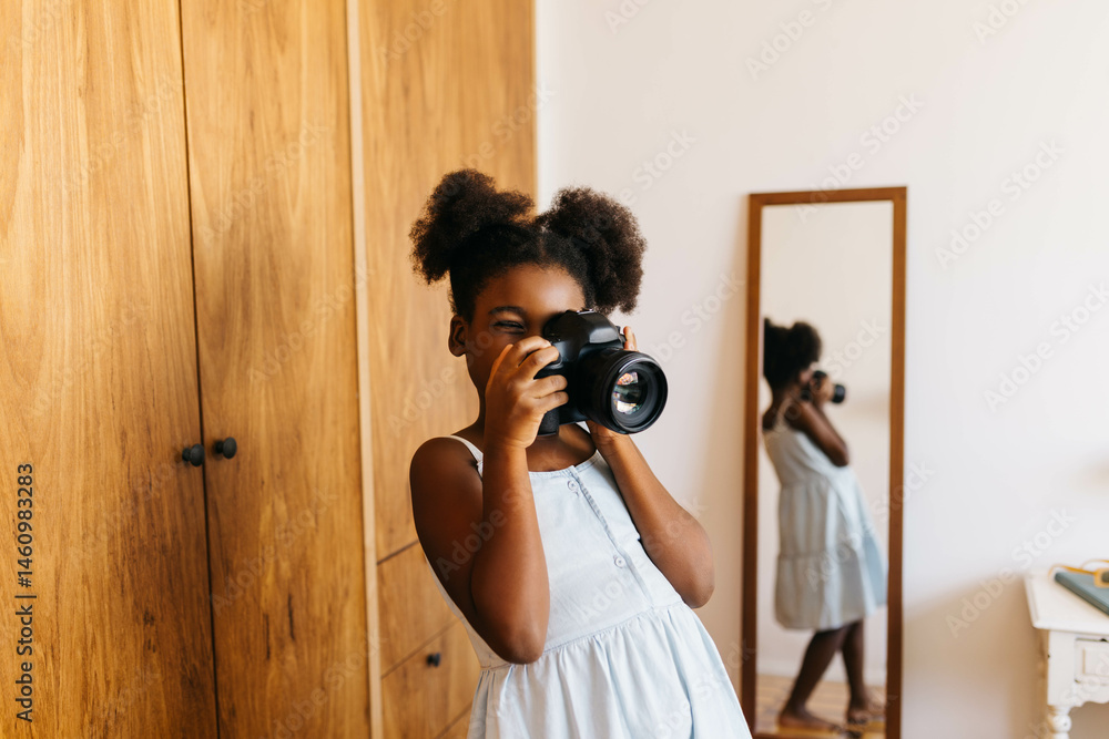 Obraz premium Creative afro-haired girl photographing a moment at home with a digital camera