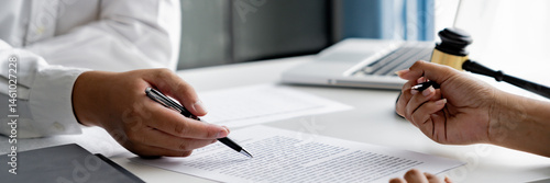 Lawyer with lawsuit meeting with client discussing with contract agreement at law firm