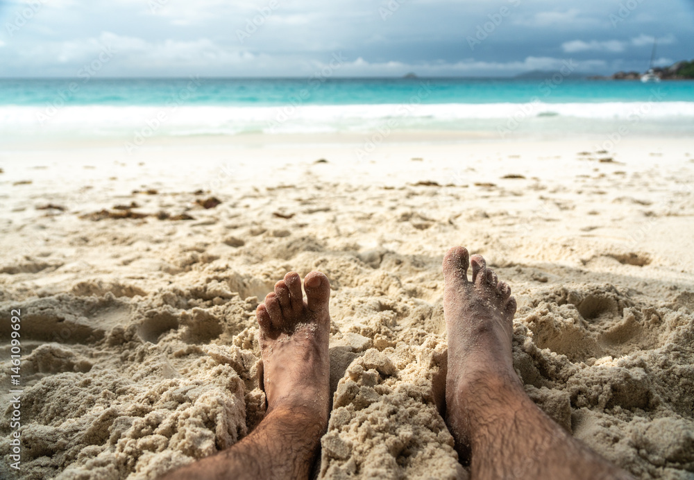 Bare feet resting in warm sand on tropical beach, symbolizing summer relaxation, freedom