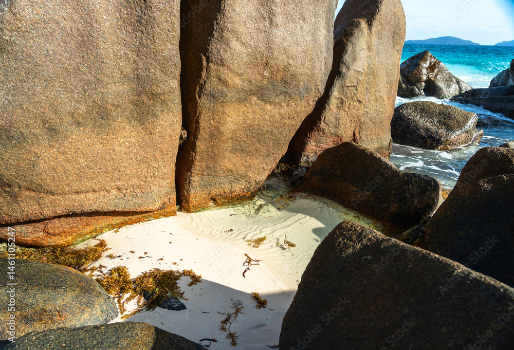Massive granite boulders and white sand create a tropical beach landscape on La Digue island