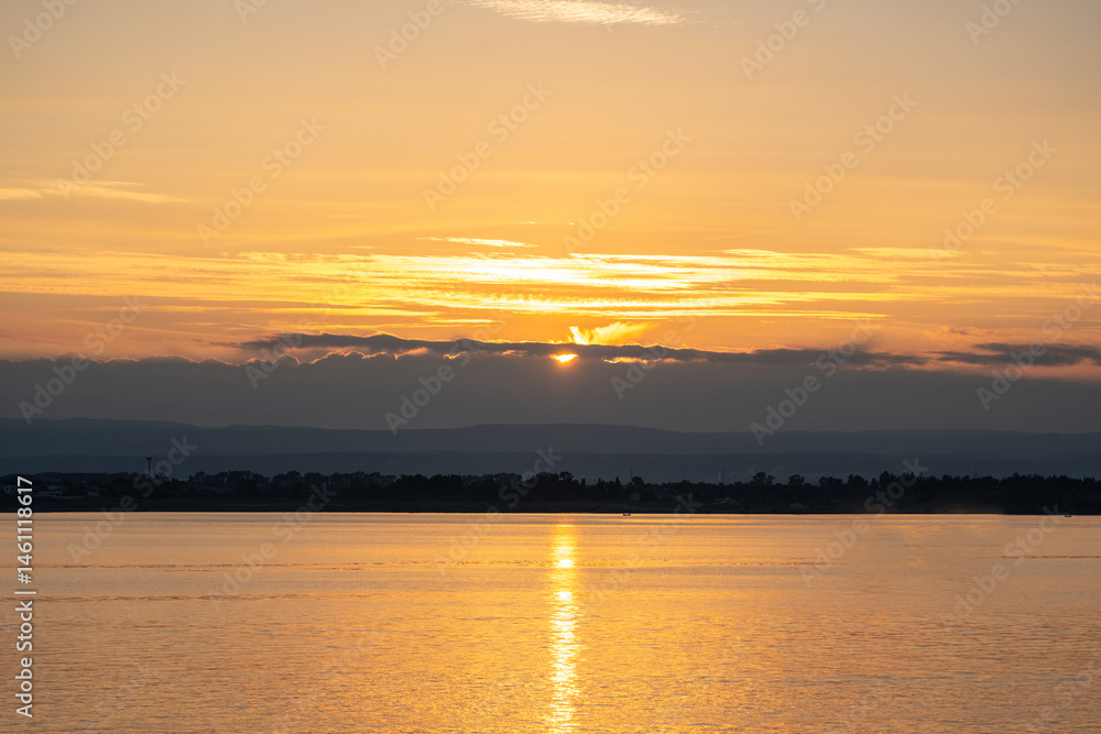 Sunset over the ocean, with the sun low on the horizon, contrast between sky and sea