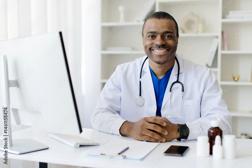 Smiling Handsome Black Male Doctor In Uniform Sitting At Desk With Computer At Workplace, Professional African American Therapist Man Wearing White Coat And Stethoscope Posing In Office At Clinic Smiling Handsome Black Male Doctor In Uniform Sitting At Desk With Computer At Workplace, Professional African American Therapist Man Wearing White Coat And Stethoscope Posing In Office At Clinic