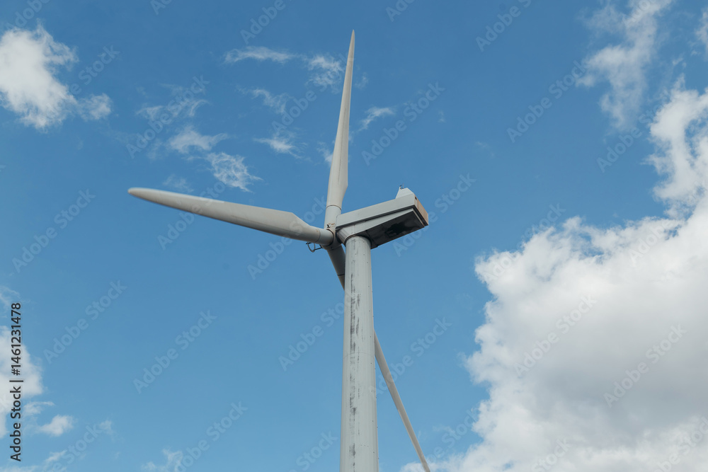 Wind Turbines with blue cloudy sky, close up, bottom view