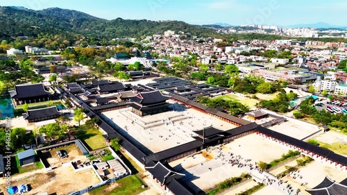 Aerial flight over Gyeongbokgung Palace towards Blue House and mountain backdrop, Seoul, South Korea