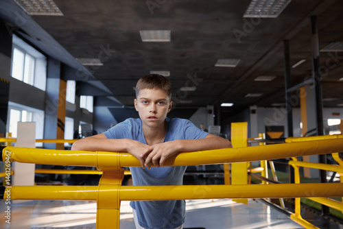 Obraz na płótnie Portrait of tired teenage boy standing in boxing ring at modern gym w salonie