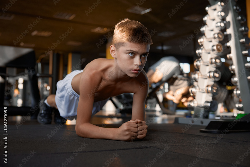 Teenage boy doing plank fitness exercise improving strength of body