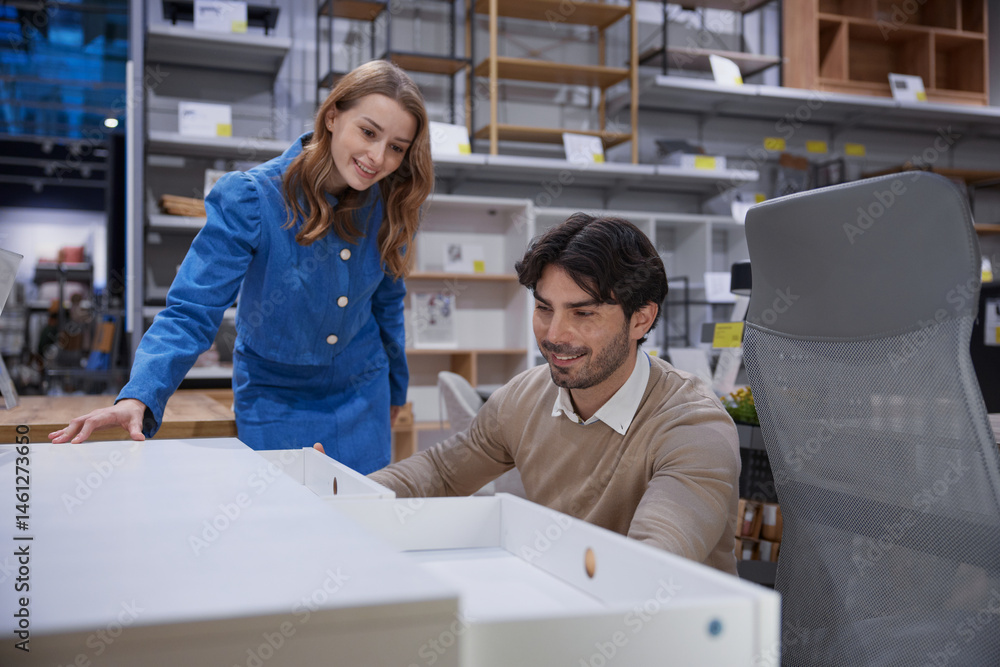 Loving couple is exploring and shopping for stylish office furniture in a modern retail store
