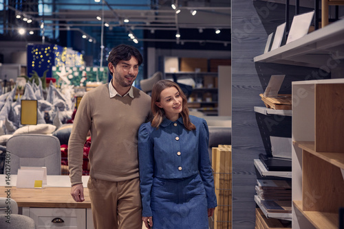 Obraz na płótnie A couple enthusiastically shopping for stylish furniture in a contemporary modern store w salonie