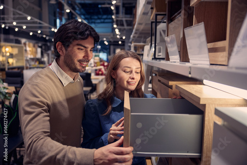 Couple explores various modern furniture options in stylish store highlighting unique designs