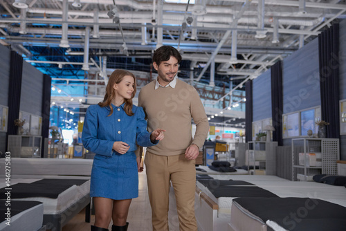 Obraz na płótnie A couple is shopping for furniture in a contemporary showroom, exploring options w salonie