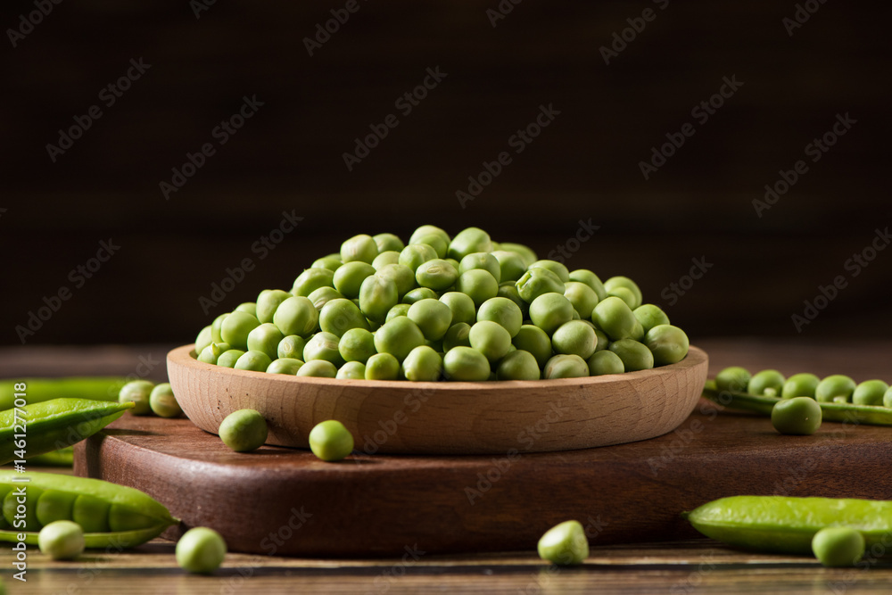 fresh green peas on wooden table.