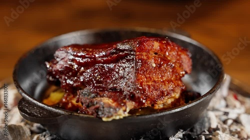 Barbecue pork ribs in cast iron skillet over hot coals, glazed with sticky sauce and slow-cooked. Close-up of juicy smoked meat with rich flavor and dark caramelized crust in rustic style.