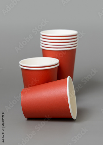 Disposable red paper cups on a gray closeup, mockup. No plastic and sustainable Christmas