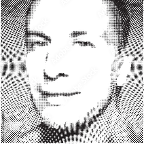 A young man gazes thoughtfully into the distance with a subtle smile.