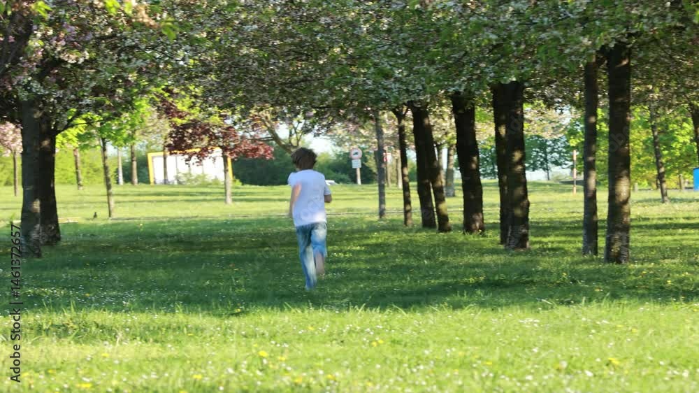 Portrait of cute stylish smiling toddler boy running in the grass in park Portrait of cute stylish smiling toddler boy running in the grass in park