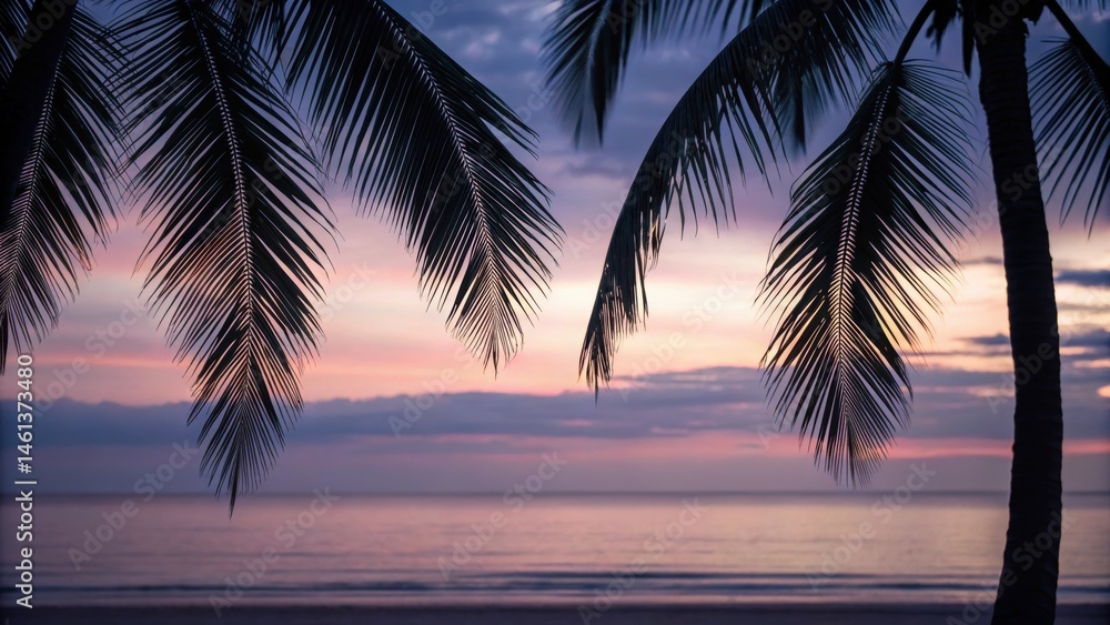 Fototapeta premium Serene beach scene at sunset with palm leaves framing the horizon and calm water reflecting warm colors.