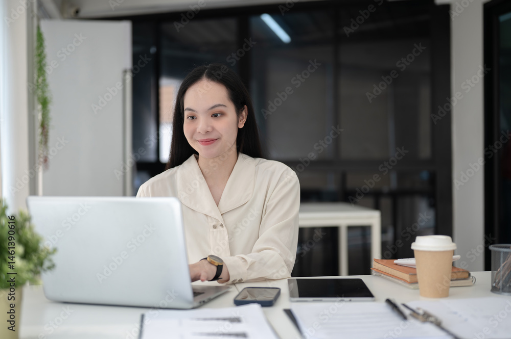 Female office worker or businesswoman typing on laptop while sitting at working table in office. Female office worker or businesswoman typing on laptop while sitting at working table in office.