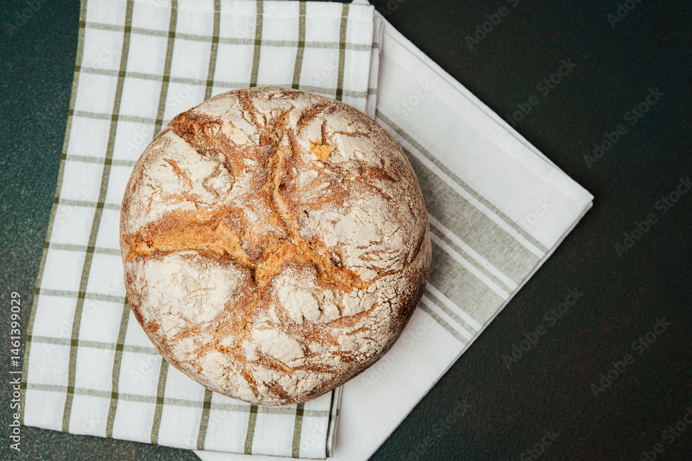 Rustic sourdough bread resting on a striped kitchen towel in a cozy kitchen