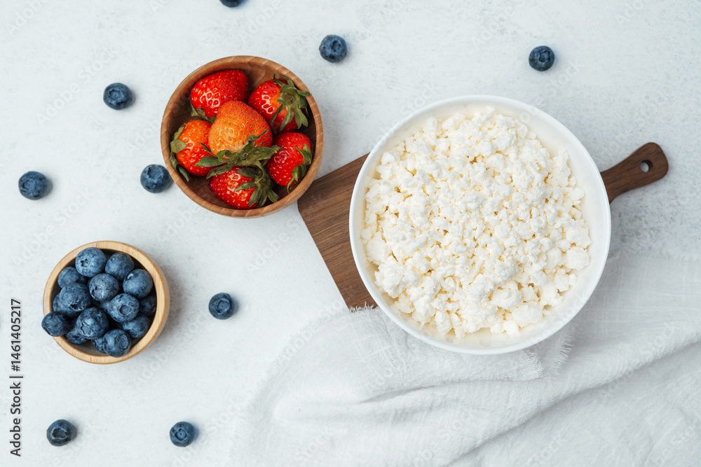 Fresh fruits and cottage cheese arranged on a clean white surface