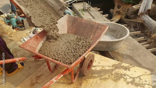 workers are pouring cement onto a cart