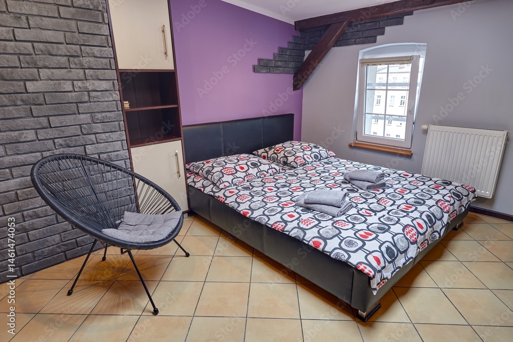 Kolorowy apartament na poddaszu z dużym łóżkiem i aneksem kuchennym