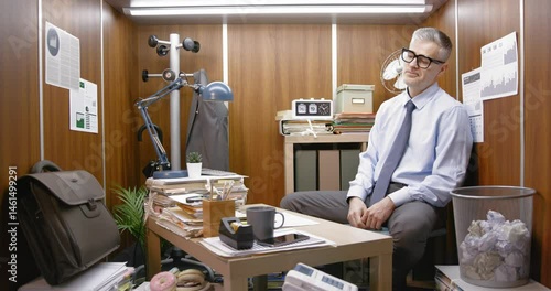 Bored inefficient employee wasting time in his small office