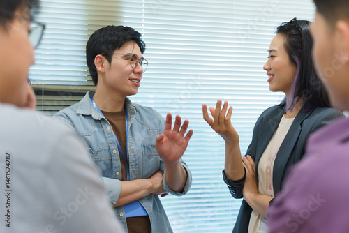 Group of young adults having a conversation in an office setting during a meeting in the afternoon