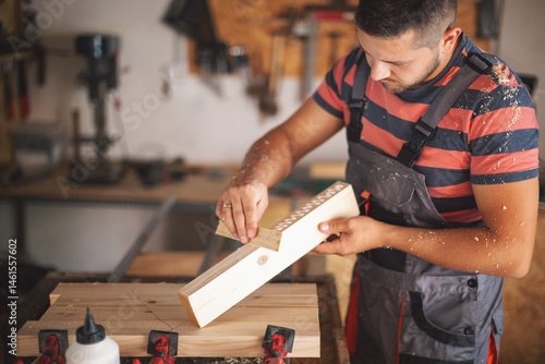 Young carpenter glueing wood