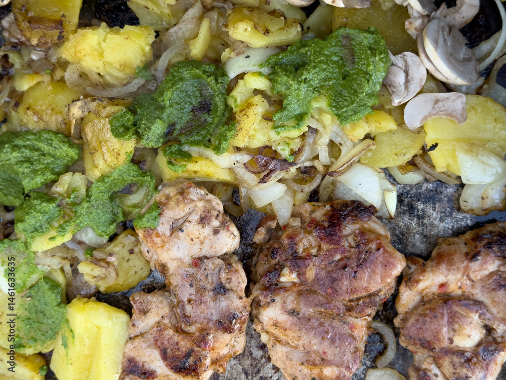 Delicious grilled chicken breast with roasted potatoes, onions, and a vibrant chimichurri sauce.